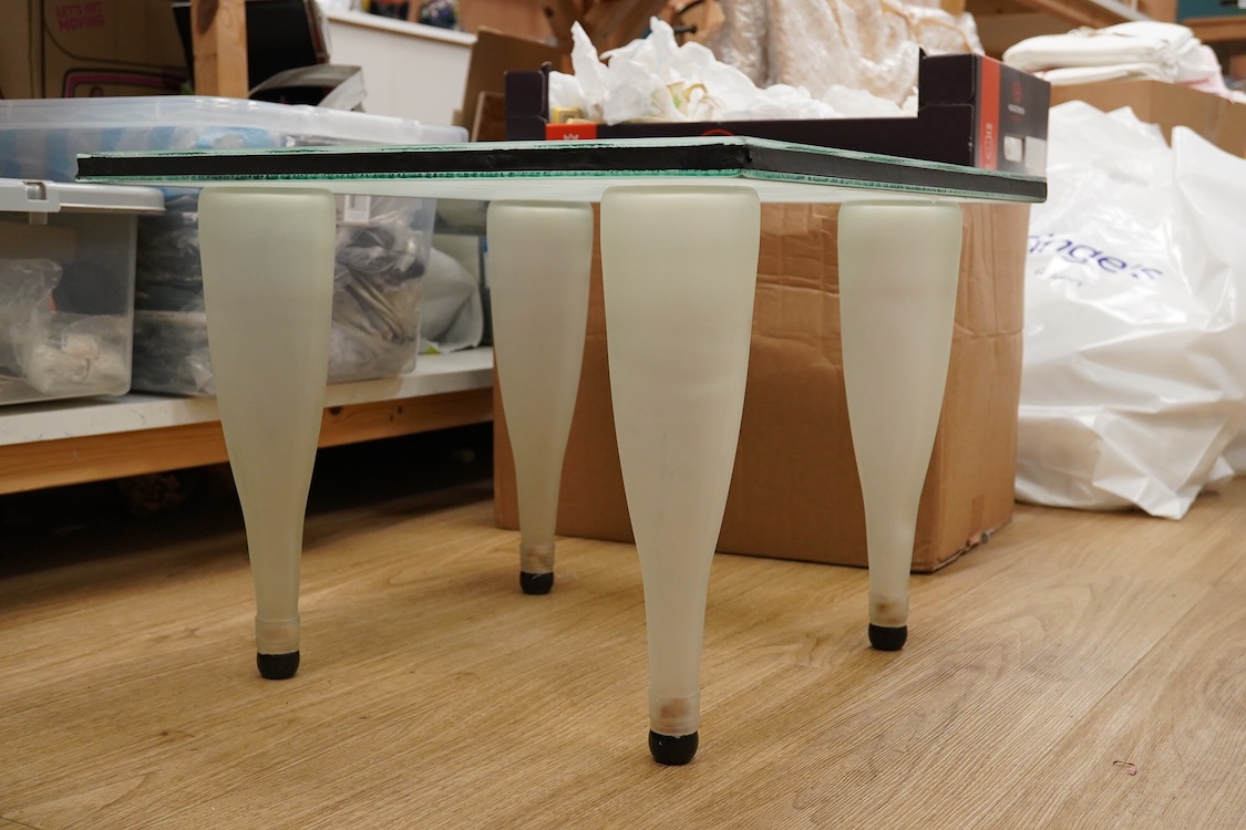 A Mary Canny an Art glass ‘Bottle table’, with abstracted checker board glass top- 49cm wide x 48cm deep x 35cm high